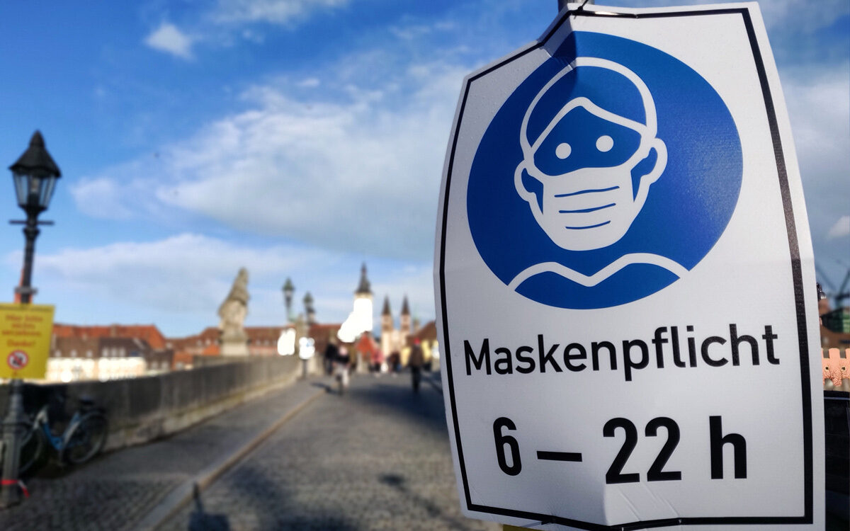 Maskenpflicht ein Schild auf der rechten Seite auf der Alten Mainbrücke in Würzburg in Zeiten von Corona Maskenpflicht ein Schild auf der rechten Seite auf der Alten Mainbrücke in Würzburg in Zeiten von Corona